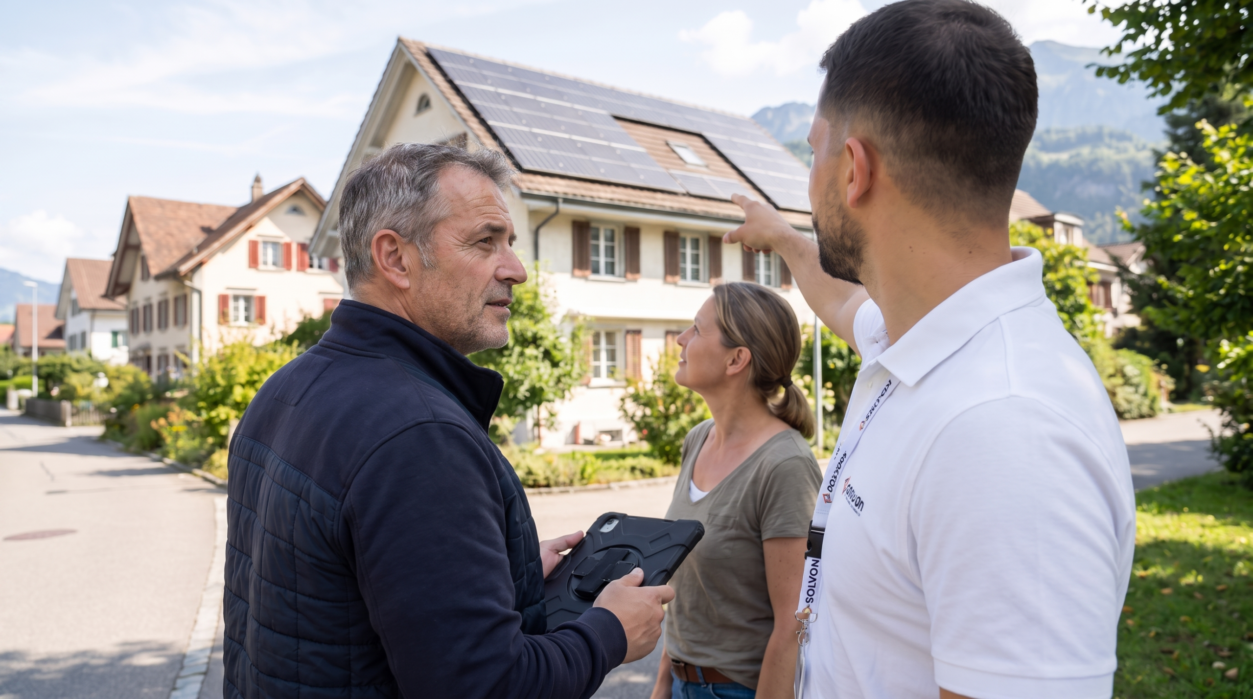 Solvon-Mitarbeiter zeigt einem Paar die Photovoltaikanlage auf dem Dach ihres Hauses